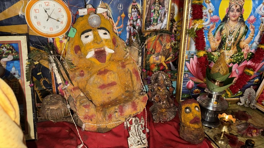 Private shrine with traditional devotional objects and a lit lamp